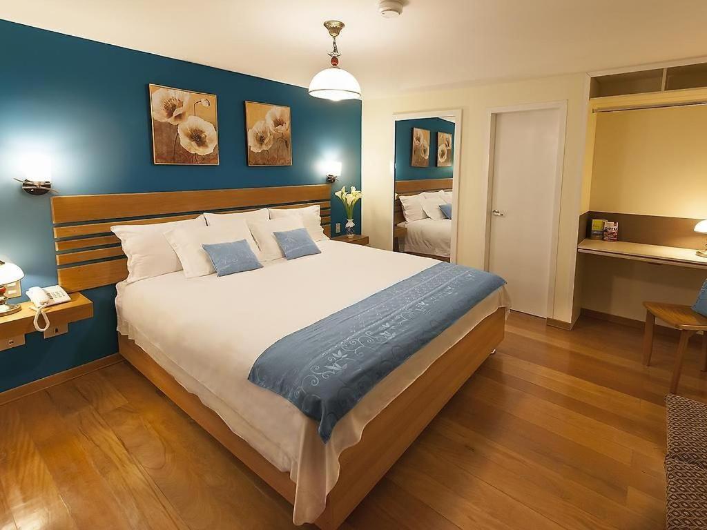 a bedroom with a large bed with blue walls at Tandapata Boutique Hotel in Cusco