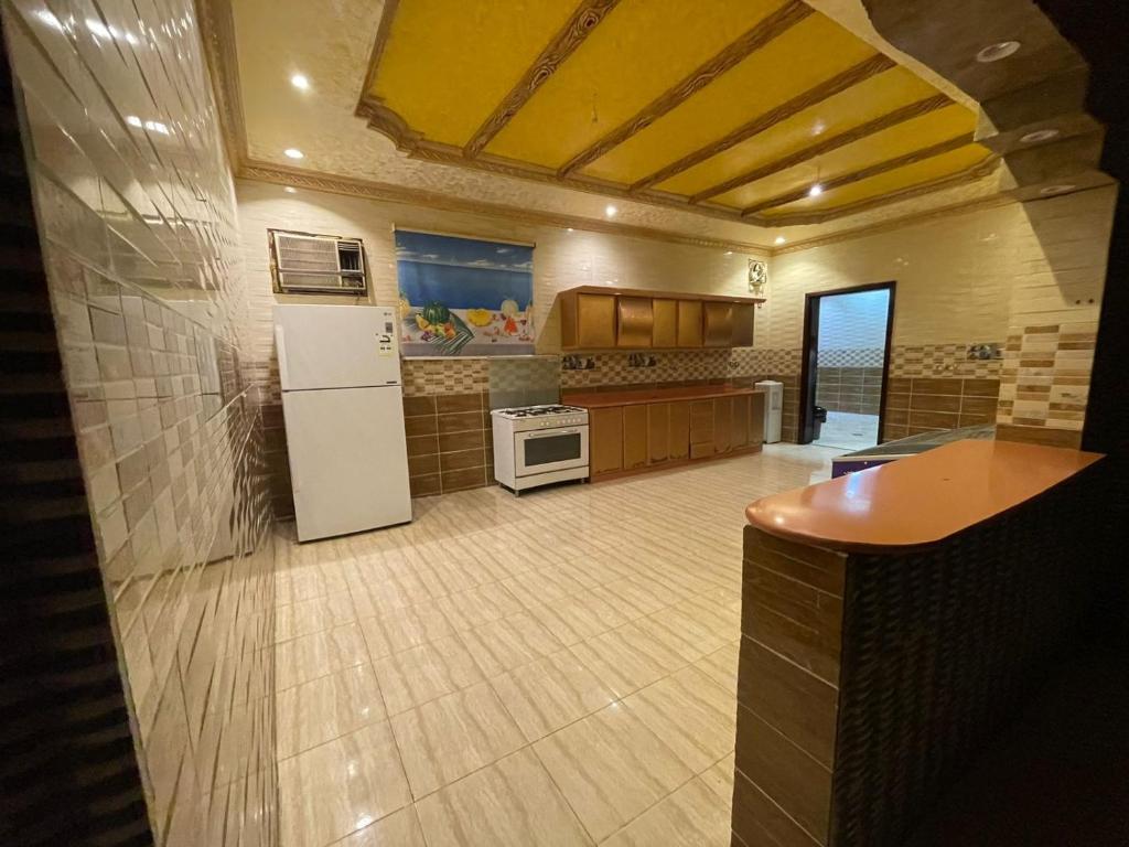 eine große Küche mit einem Kühlschrank und einem Herd in der Unterkunft شاليه الفوز 2 in Medina