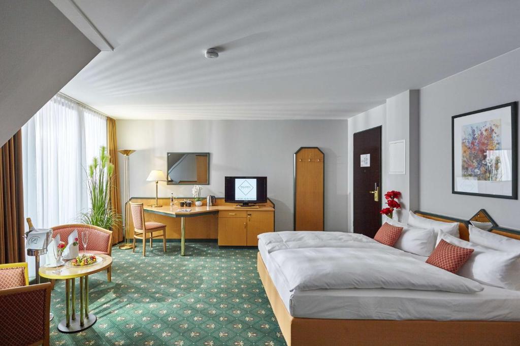 a hotel room with a bed and a desk at Balance Hotel Leipzig Alte Messe in Leipzig