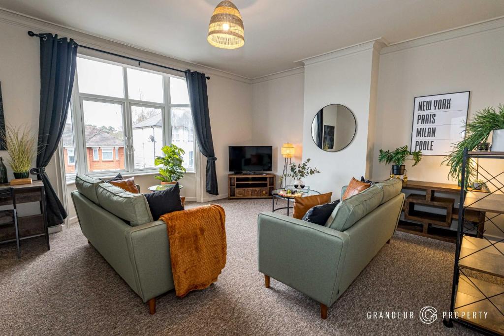 uma sala de estar com dois sofás e uma televisão em New! Stylish 2 bed flat with parking near beach - Parkstone Central em Parkstone