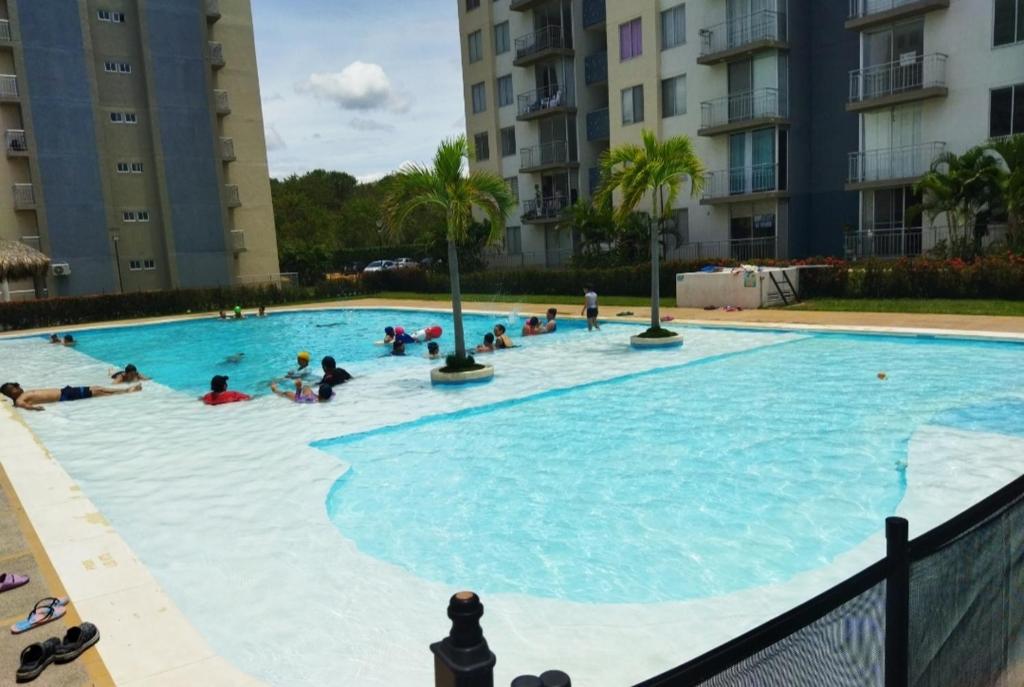 un groupe de personnes se baignant dans une grande piscine dans l'établissement Habitación con piscina, à Flandes