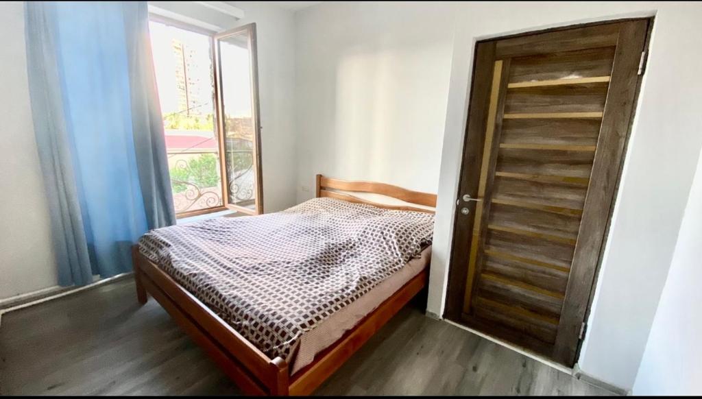 a small bedroom with a bed and a door at Varcov bnakaran in Yerevan