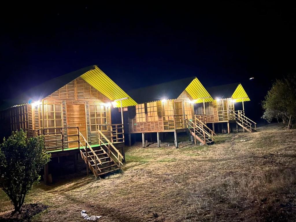 una fila de cabañas de madera iluminadas por la noche en Hotel Campestre Cabañas de la Sierra Nevada de El Cocuy, en Panqueba