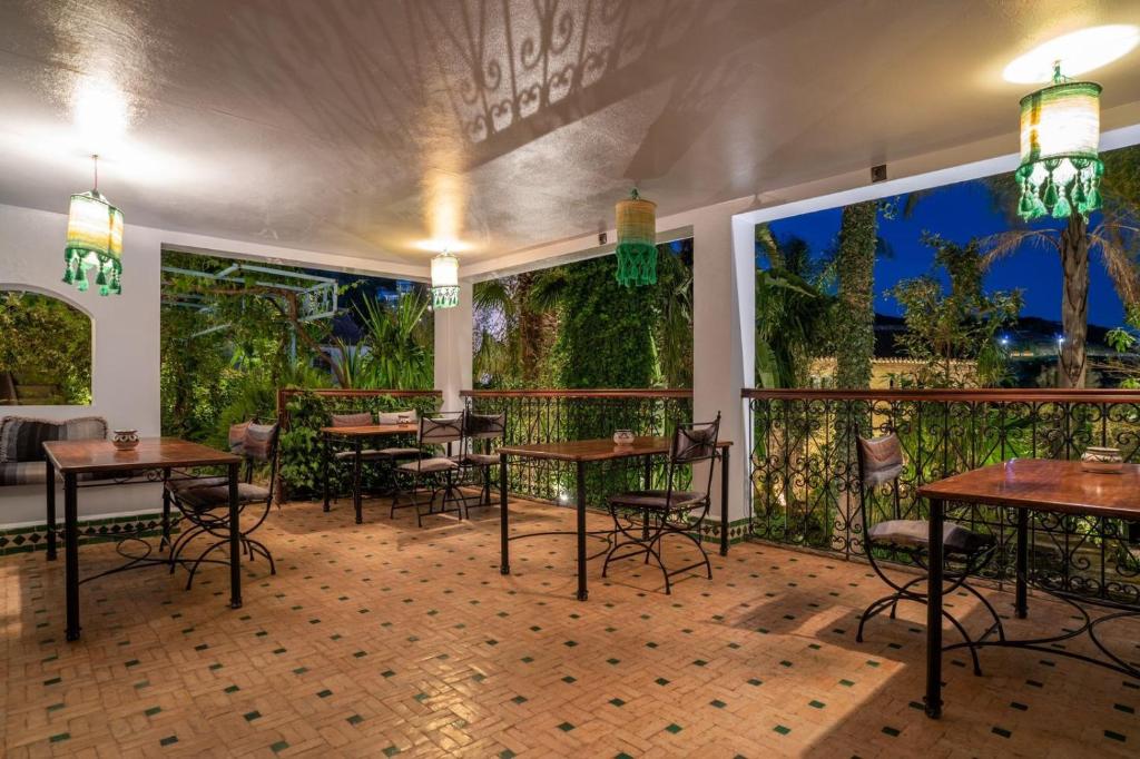 Hotel Molino Garden في شفشاون: مطعم بطاولات وكراسي وجدارية كبيرة