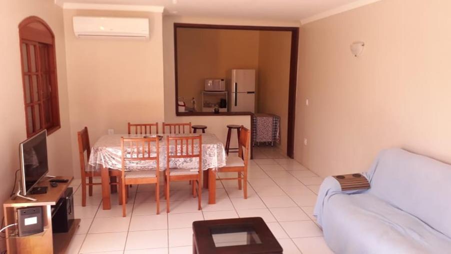 uma sala de estar com mesa e cadeiras e uma cozinha em Sobrado na Praia do Laranjal em Pelotas