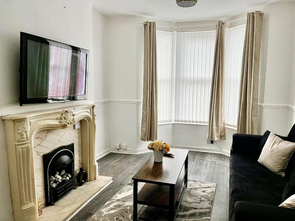a living room with a fireplace and a tv at Crystal House- Liverpool City in Litherland