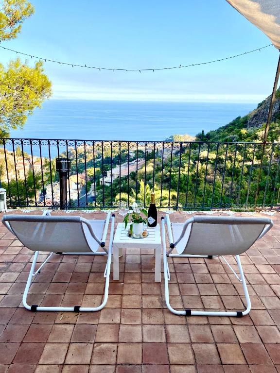 a table and chairs on a patio with a view of the ocean at Casa dei sogni in Taormina
