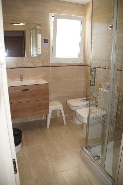 a bathroom with a toilet and a sink and a shower at Hotel Roca Bella in Es Pujols