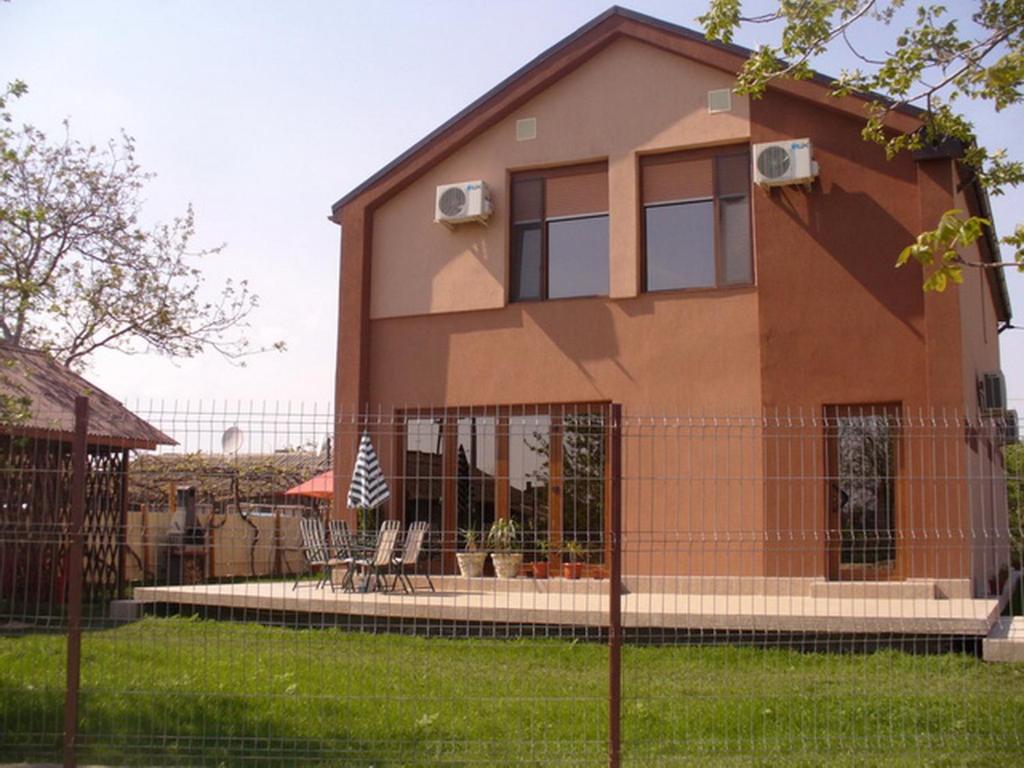 a house with a fence in front of it at Pensiunea Socrita in Corbu