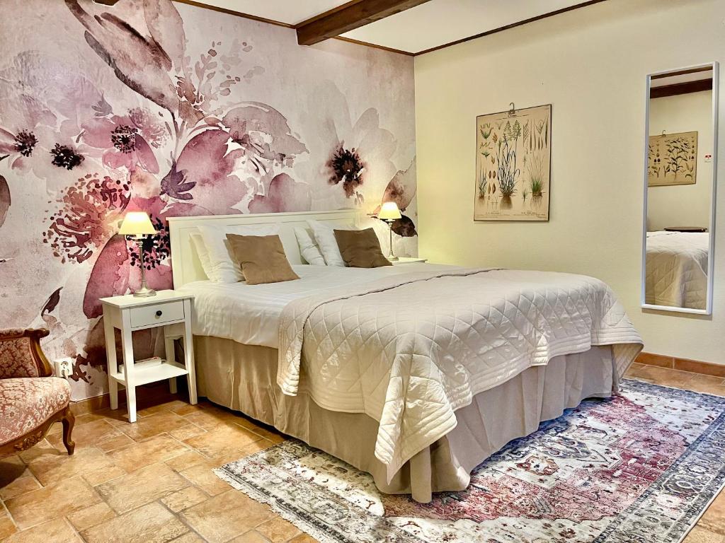 um quarto com uma cama com papel de parede floral em Sydkustens at Lillehem em Skivarp