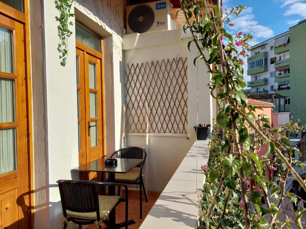 a balcony with a table and chairs and plants at Godard Apartments in Vlorë