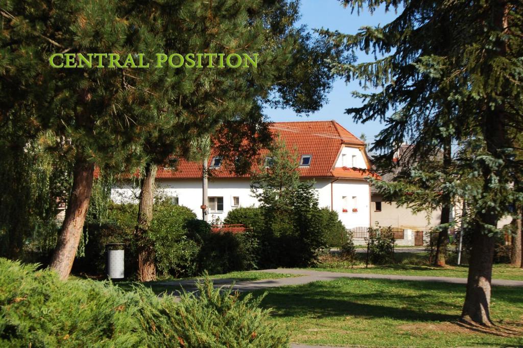 a house in a park with trees in the foreground at Penzión Belvia in Nová Lesná