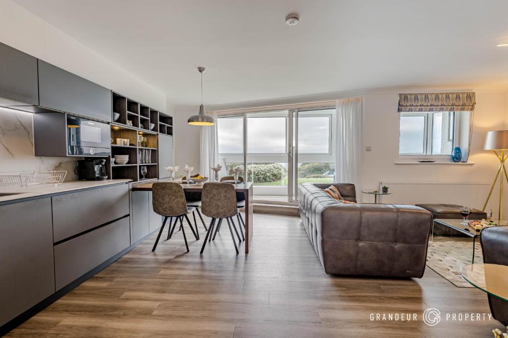 a kitchen and living room with a couch and a table at Shoreline Suite by Grandeur Property in Southbourne