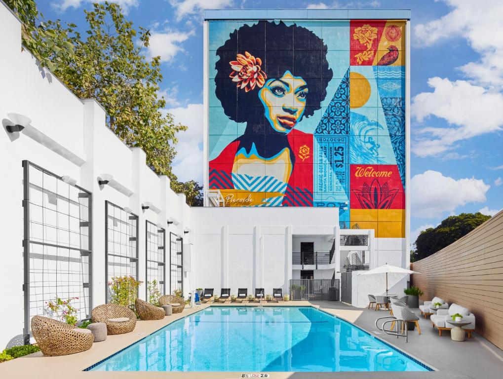 un mural en el lateral de un edificio con piscina en The Pierside Santa Monica en Los Ángeles