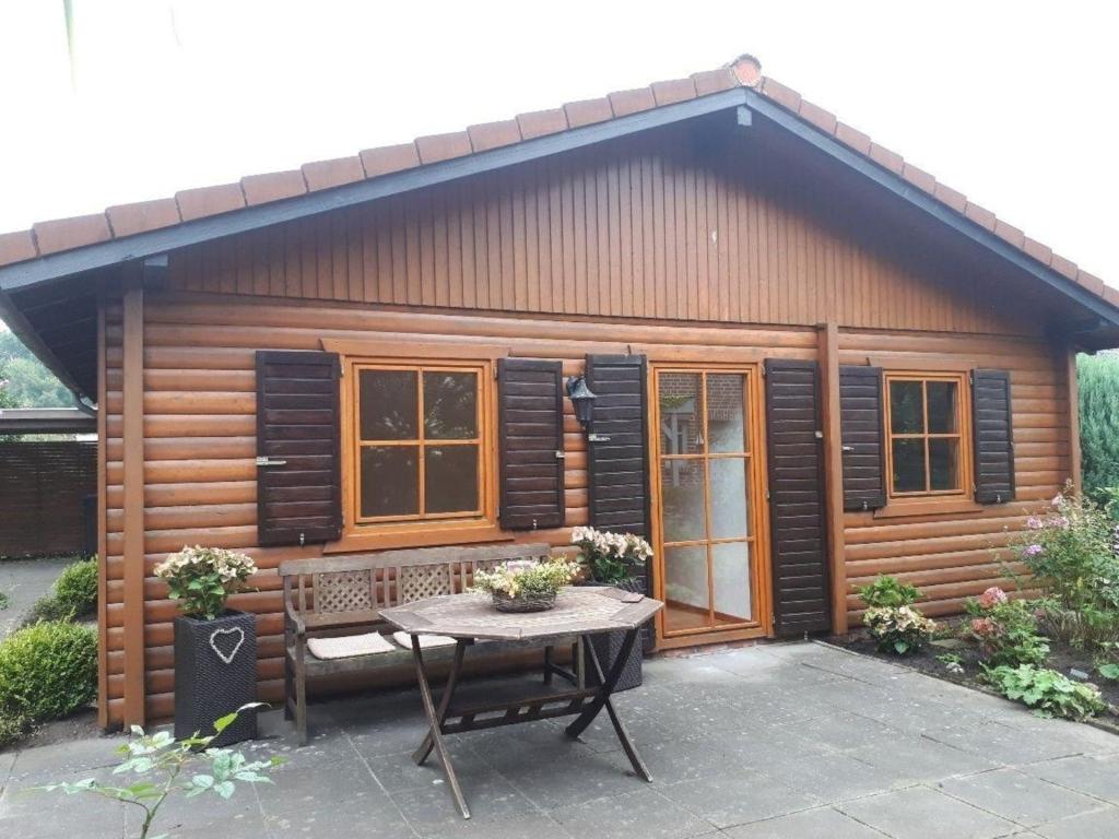 eine kleine Hütte mit einem Tisch davor in der Unterkunft Blockhaus im Grünen in Oldenburg