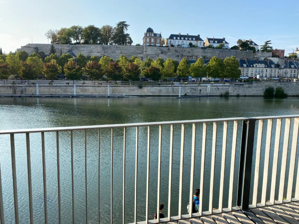 two people standing on a bridge over a river at Résidence Amaya - haut standing au bord de l'Oise in Pontoise