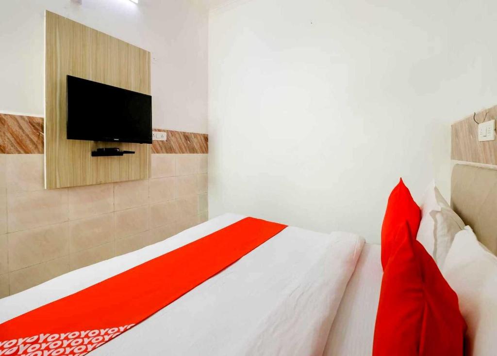a bedroom with a bed with a tv on the wall at Collection O 81235 Hotel Aashiyana in New Delhi