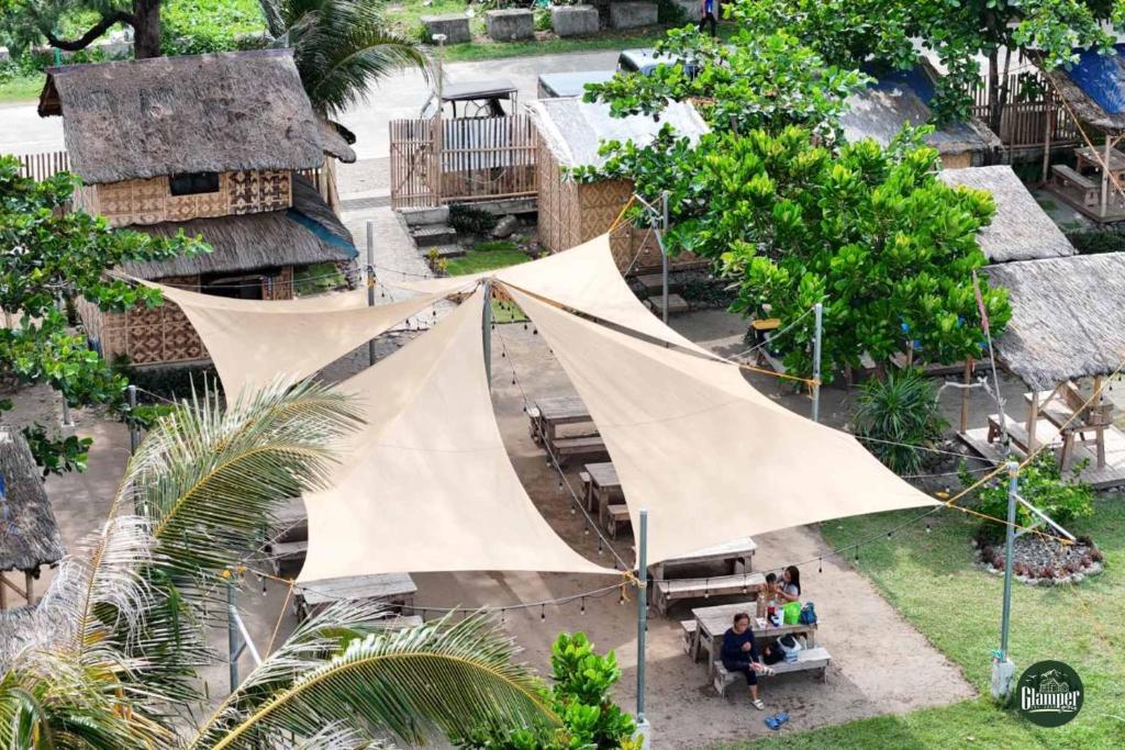 a group of people sitting under a tent in a yard at Glamper Grove- Real, Quezon 