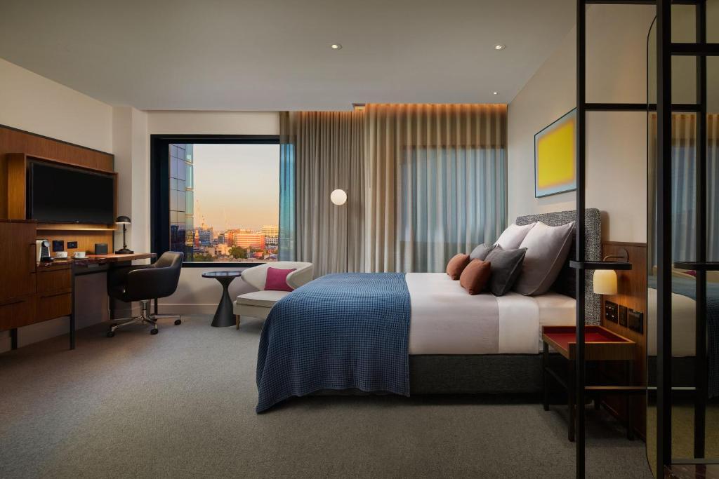 a hotel room with a bed and a desk and a desk at Next Hotel Melbourne, Curio Collection by Hilton in Melbourne