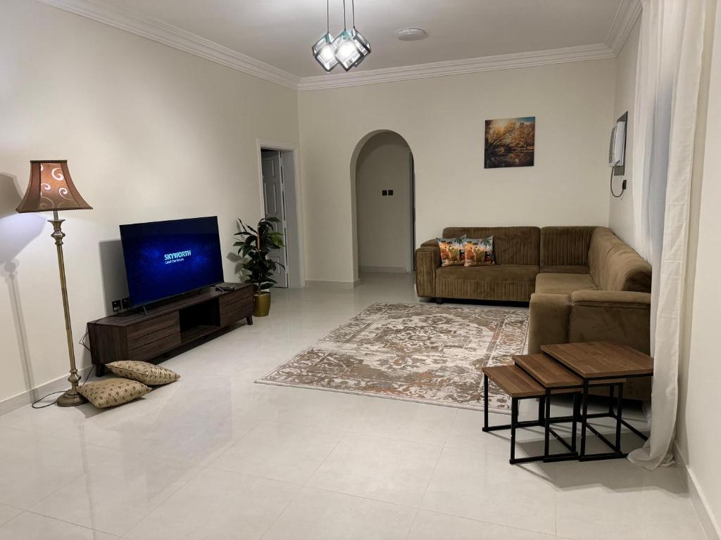 a living room with a couch and a tv at Almadina Laxury Apartemetns in Al Madinah