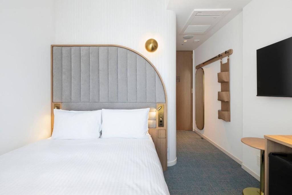 Postel nebo postele na pokoji v ubytování Hotel Comento Yokohama Kannai