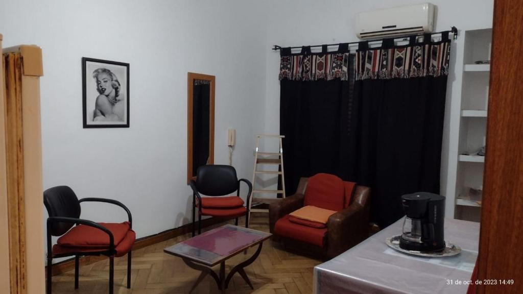 布宜諾斯艾利斯的住宿－departamento tucuman 672，客厅配有椅子和黑色窗帘