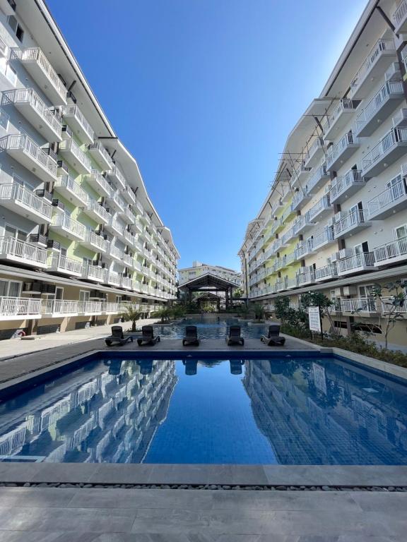 a swimming pool in the middle of two buildings at Seaview Amani Grand Resort Residences 3-5mins from airport in Mactan