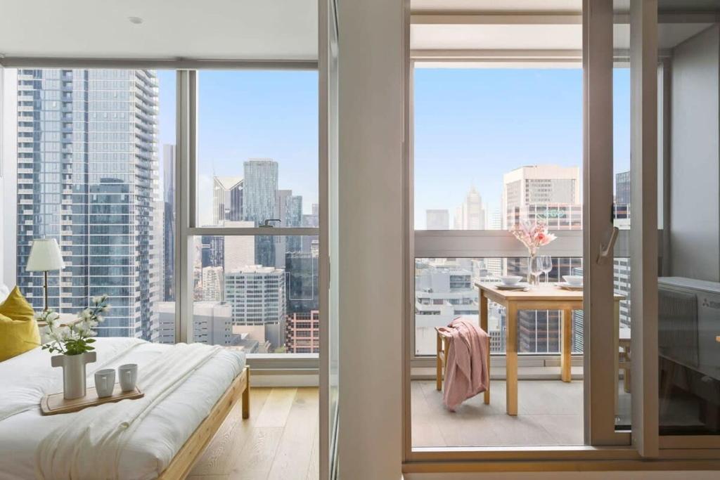 1 dormitorio con ventana grande con vistas a la ciudad en A Comfy 2BR Apt w City Views Near Southern Cross en Melbourne