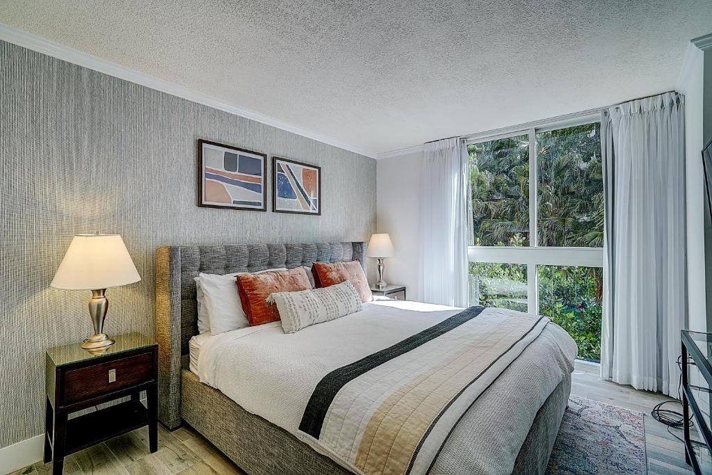a bedroom with a bed and a large window at Cute 1 bedroom unit located in Condo Hotel in the heart of Coconut Grove Free Parking in Miami