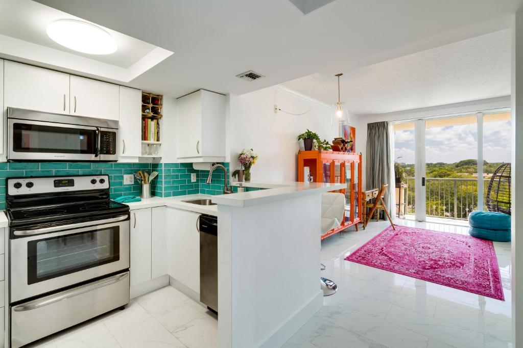 een keuken met witte kasten en een groot raam bij Coconut Grove Retreat 1 bedroom apartment with Bay views in Miami