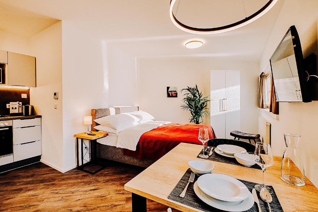 a bedroom with a bed and a table with plates on it at URBAN ISLAND I Riverside Apartments in Vienna