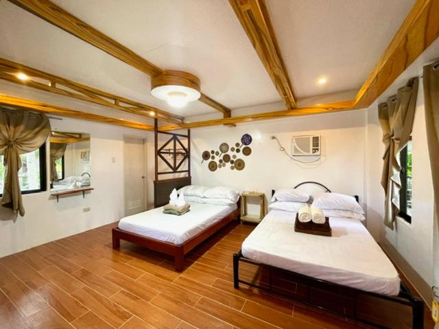 um quarto com duas camas num quarto em LANGOJON JIANJOY BEACH RESORT em Libertad