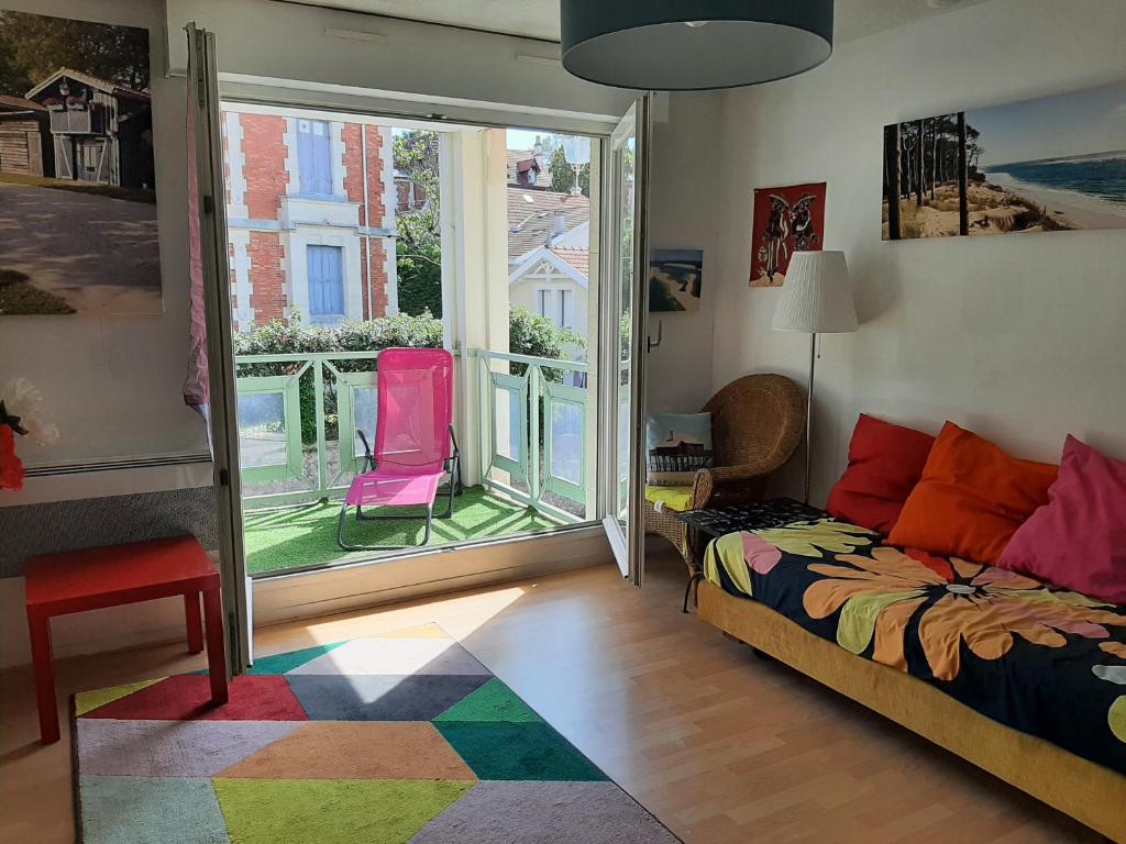 - une chambre avec un lit et un balcon avec des chaises roses dans l'établissement Appartement T3 avec Parking, Proche Centre et Plage - Arcachon - FR-1-319-492, à Arcachon