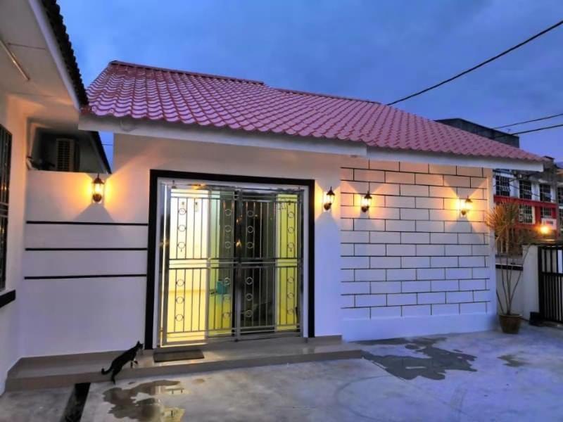 a small white house with a yellow door at Pantai Remis Homestay 118A in Pantai Remis