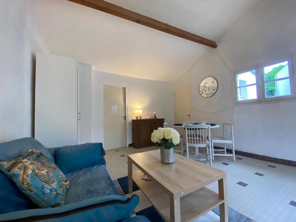 ein Wohnzimmer mit einem blauen Sofa und einem Tisch in der Unterkunft Maison Saint-Brevin-les-Pins, 1 pièce, 2 personnes - FR-1-364-158 in Saint-Brevin-les-Pins