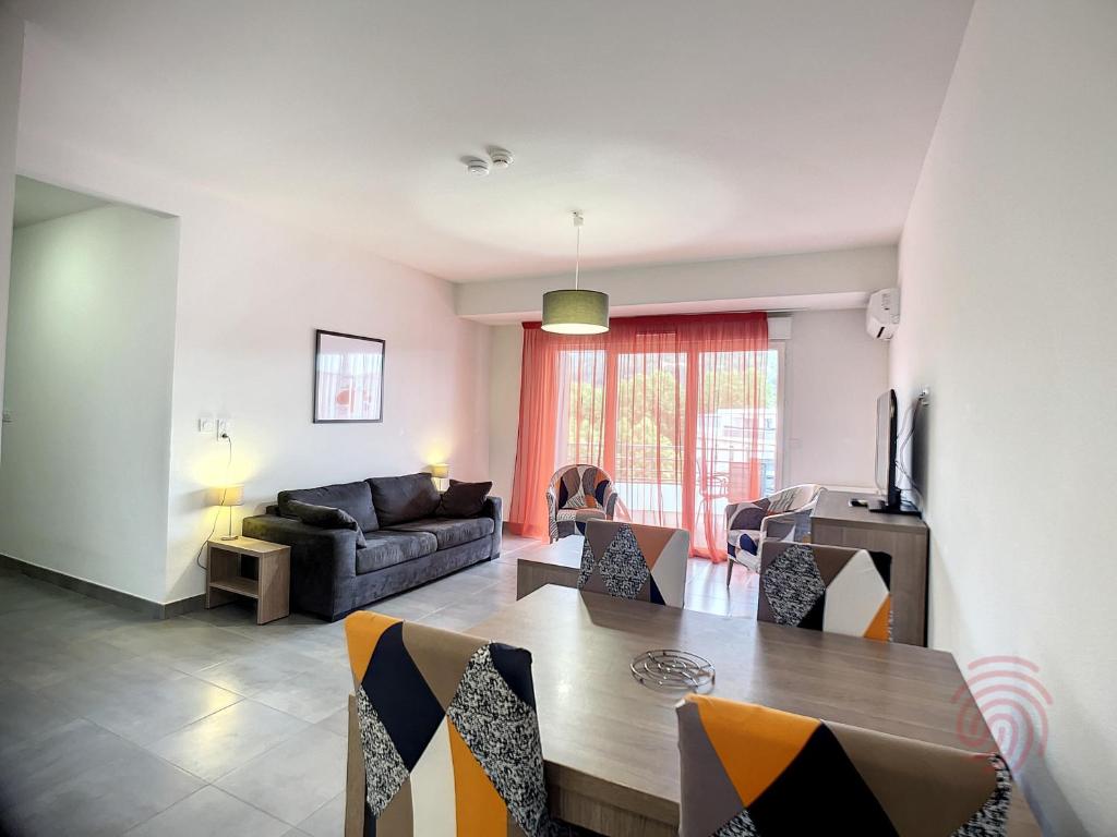 un salon avec une table et un canapé dans l'établissement Appartement F2 PMR, climatisé, avec terrasse et parking privé, au cœur de Lamalou-les-Bains - FR-1-451-194, à Lamalou-les-Bains
