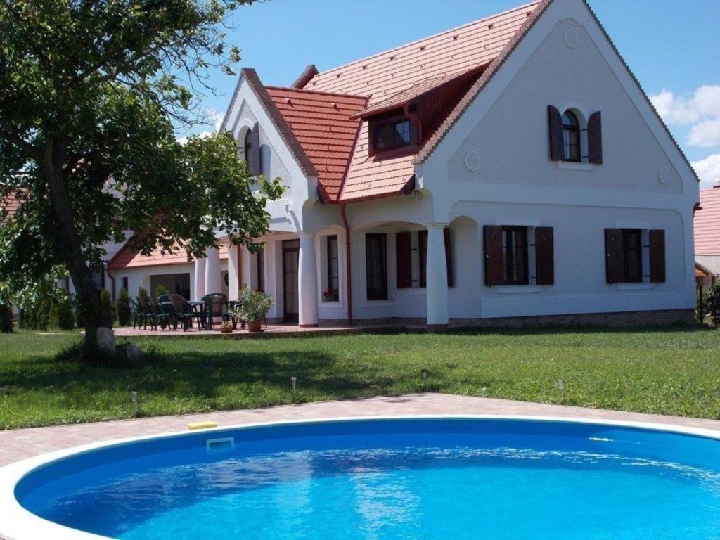 a house with a blue pool in front of it at Ferienhaus für Gruppen mit großem Garten, Terrasse und fünf Parkplätzen gegenüber von einer Reitschule in Nagyvázsony