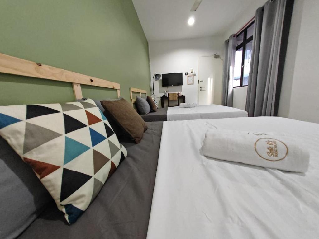 ein Hotelzimmer mit 2 Betten und einem TV in der Unterkunft Suite Us Guesthouse Kubang Kerian in Kota Bharu