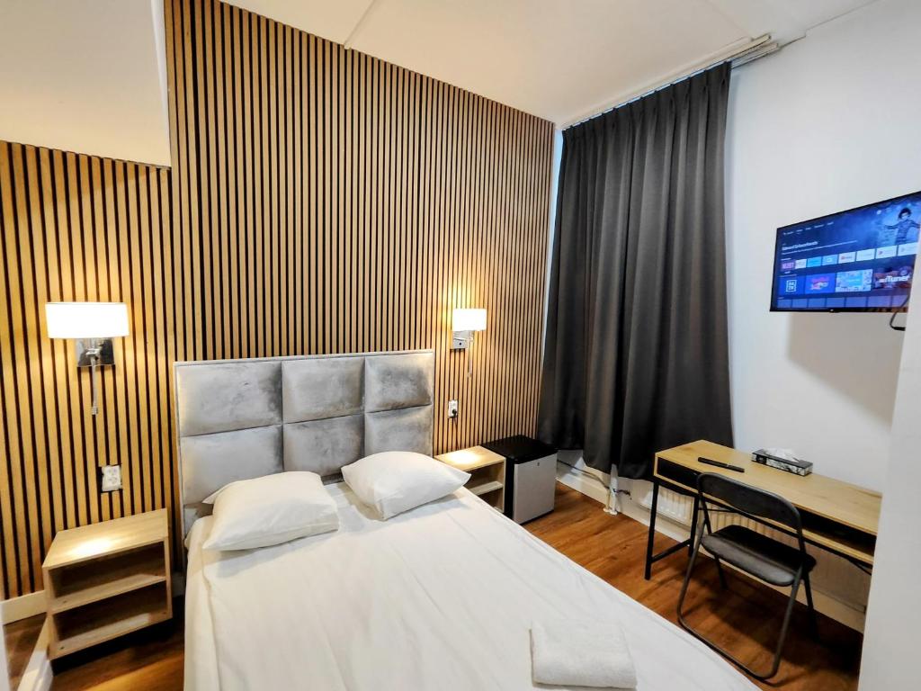 a hotel room with a bed and a desk at Hotel Holland Lodge in Utrecht