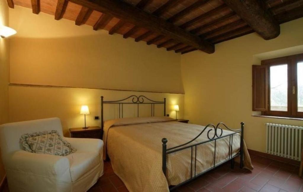 ein Schlafzimmer mit einem Bett, einem Stuhl und einem Fenster in der Unterkunft Appartement in Figline Valdarno mit gemeinsamem Pool, Grill und Terrasse in Figline Valdarno