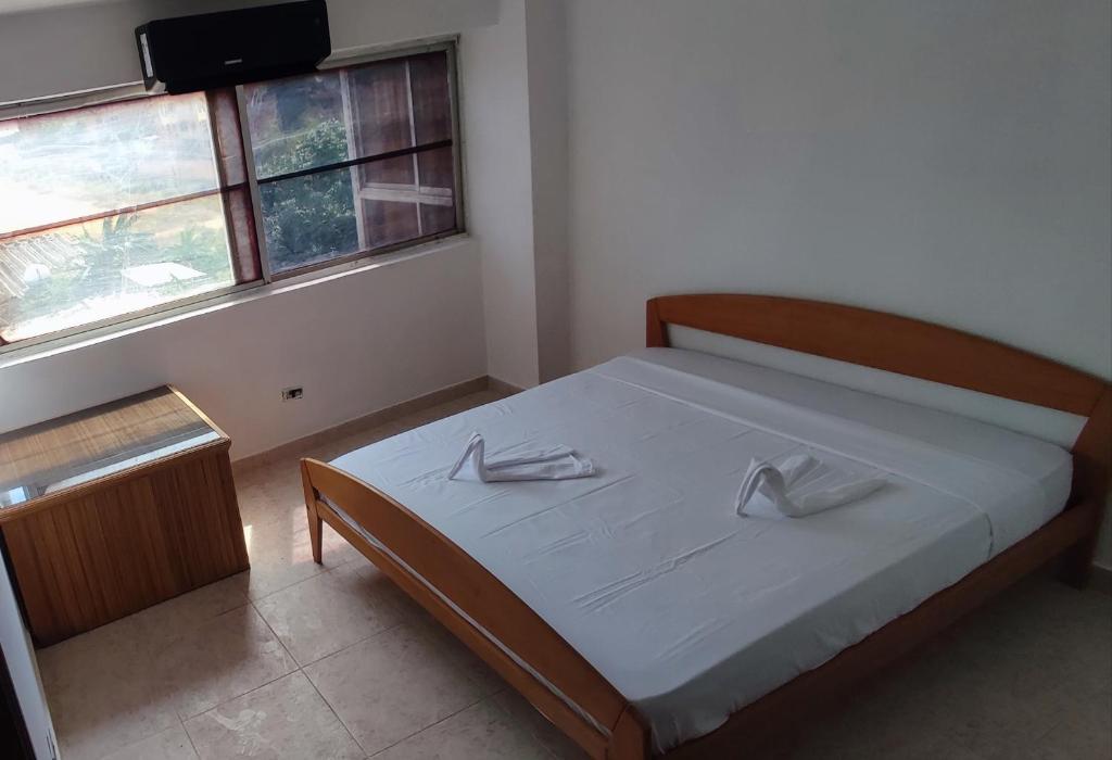 - une chambre avec un lit avec deux chaussures dans l'établissement Apartamento en Tucacas, à Tucacas