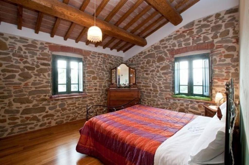 a bedroom with a bed in a stone wall at Nettes Appartement in Mignana mit gemeinsamem Pool und Panoramablick in Vinci