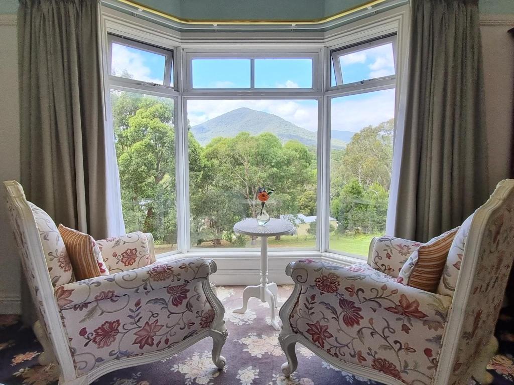 um quarto com duas cadeiras e uma grande janela em Rosebank Guesthouse em Healesville