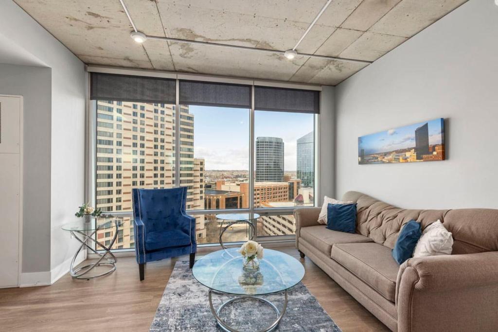 a living room with a couch and a large window at Luxury 2BR Penthouse in Downtown GR in Grand Rapids
