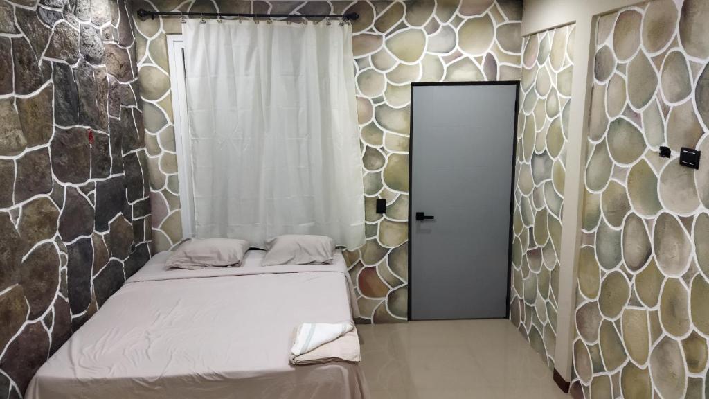 a small room with a bed and a door at Casa Lolita's in San Juan La Laguna