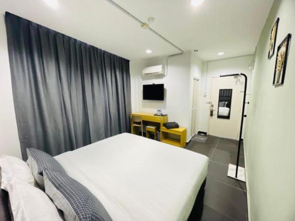 a hospital room with a bed and a desk at Halo Rooms Hotel in Wakaf Baharu