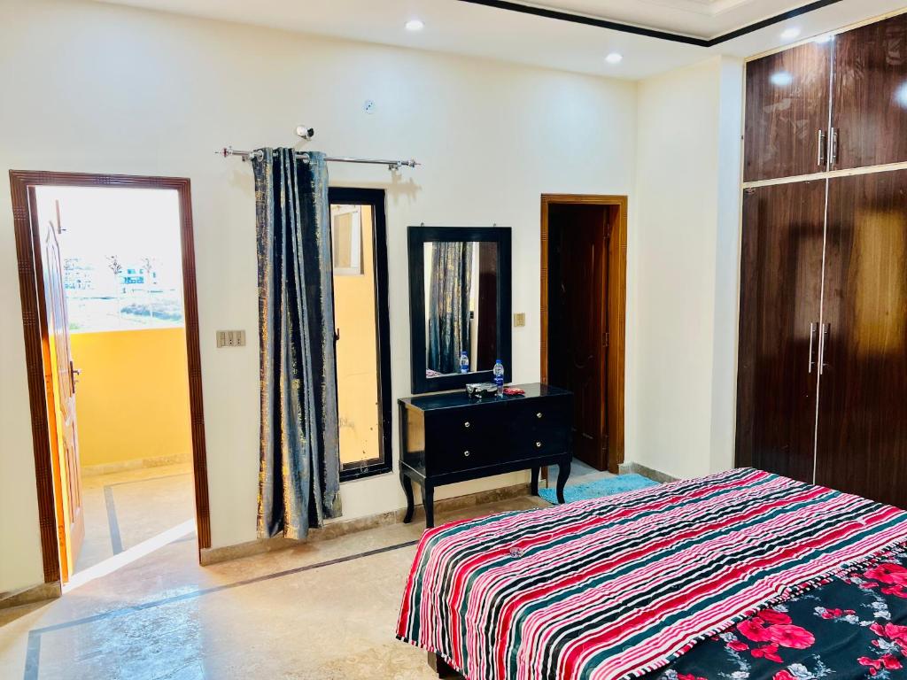 um quarto com uma cama, uma cómoda e um espelho em Golden Plaza em Gujrānwāla