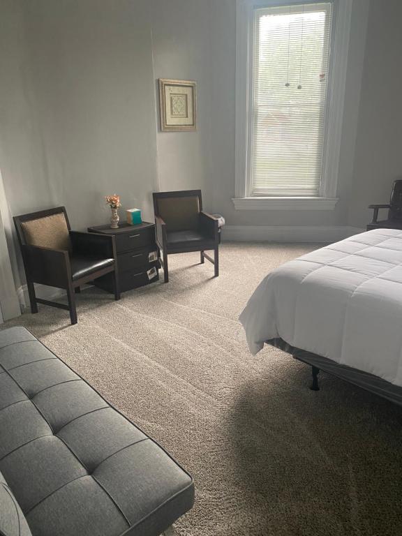 1 dormitorio con 1 cama, 2 sillas y mesa en Walnut Hills Studio/ Private room, en Cincinnati