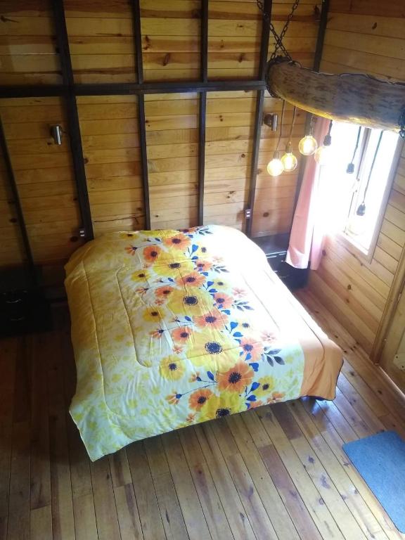 a bedroom with a bed in a wooden room at CABAÑA MINCHY in Mazamitla