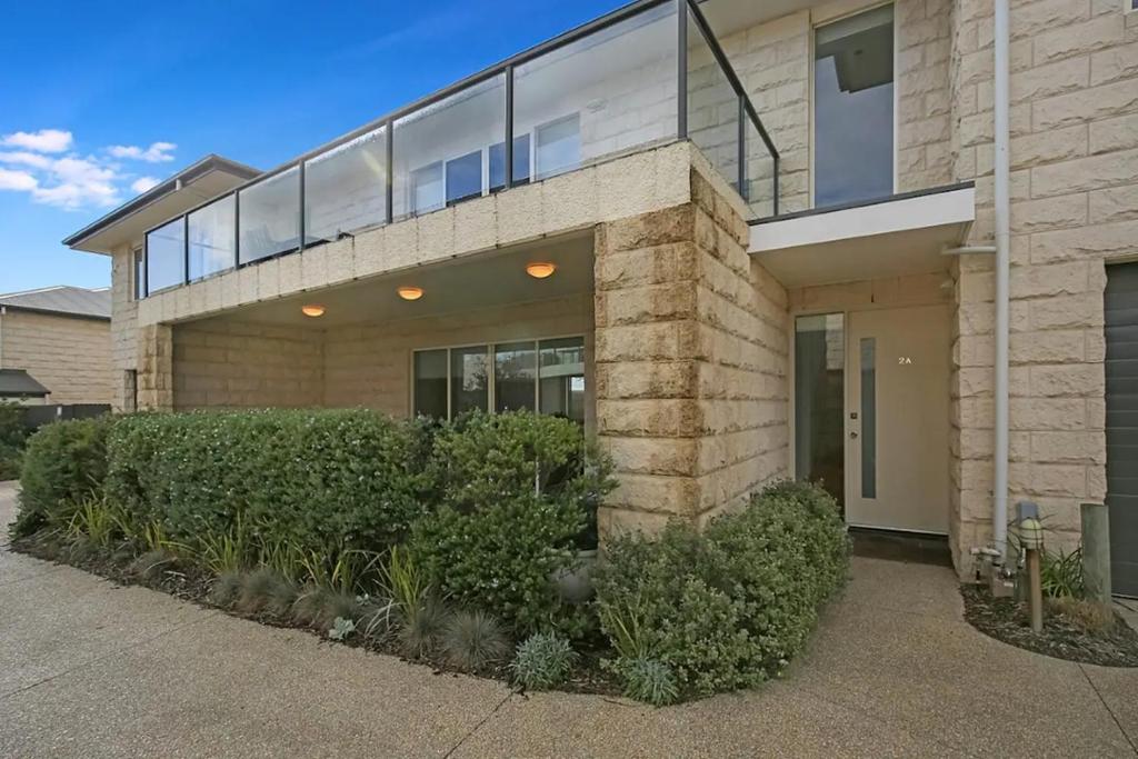 a brick house with glass windows and bushes at Sorrento Del Mar by Ready Set Stay in Sorrento